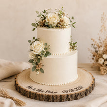 Load image into Gallery viewer, Natural wooden wedding cake stand with personalised Mr and Mrs engraving and rustic bark edge detail.
Custom engraved log slice cake stand for wedding cakes, featuring natural wood grain, bark edging and handmade rustic styling.