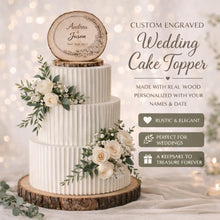 Load image into Gallery viewer, May include: A three-tiered white wedding cake with a wooden cake topper engraved with names and a date. The cake is decorated with white roses and greenery. The cake sits on a wooden base. Text on the image reads "Custom Engraved Wedding Cake Topper".
